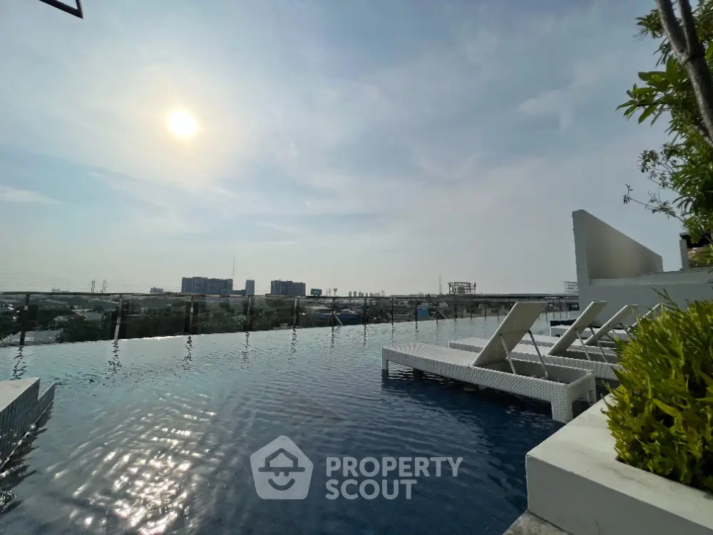 Stunning rooftop infinity pool with panoramic city views and modern lounge chairs.