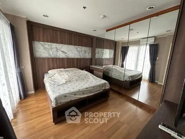 Spacious bedroom with mirrored wardrobe and natural light