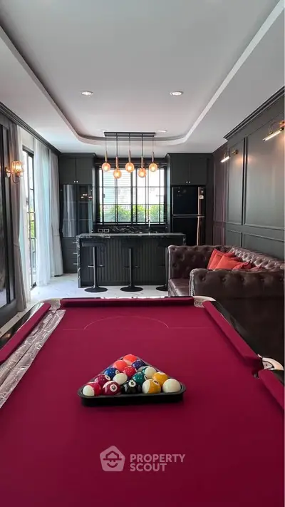 Luxurious living room with pool table and modern kitchen in elegant home