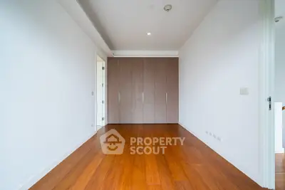 Spacious empty room with wooden flooring and built-in wardrobe, perfect for customization.
