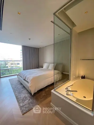 Luxurious bedroom with glass-enclosed bathtub and stunning city view, perfect for modern living.