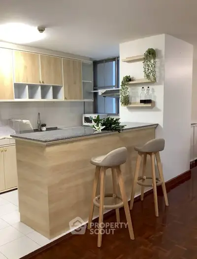 Modern kitchen with breakfast bar and stylish stools in open layout design.