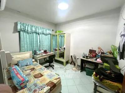 Cozy bedroom with study area, featuring a single bed, desk, and wardrobe, ideal for students or young professionals.