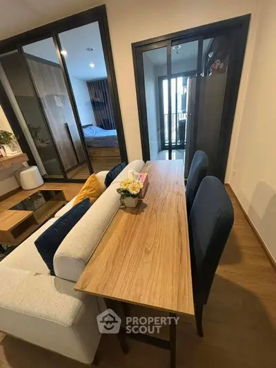 Modern living room with dining area and view into cozy bedroom
