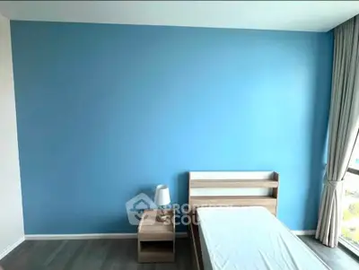 Modern bedroom with blue accent wall and minimalist furniture