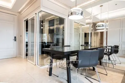 Modern dining area with sleek black table and chairs, mirrored walls, and elegant lighting.