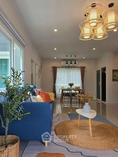 Stylish living room with modern decor, blue sofa, and dining area in open layout.
