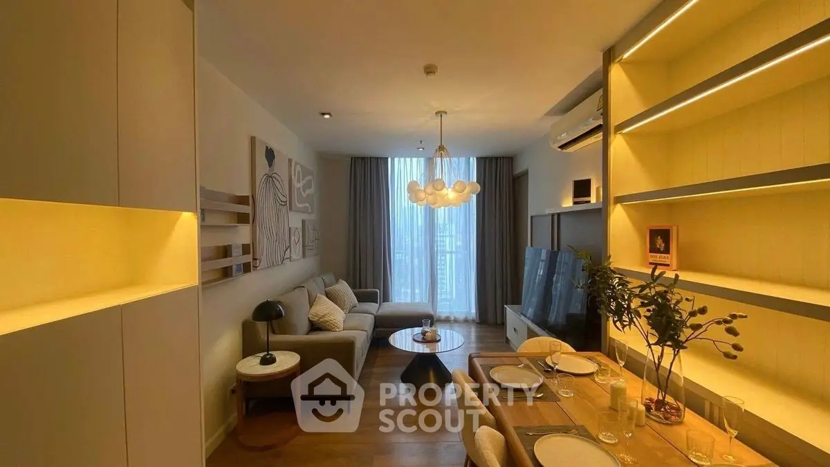 Stylish modern living room with elegant decor and dining area, featuring warm lighting and contemporary furnishings.