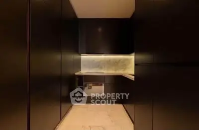 Luxurious modern kitchen with sleek dark cabinetry and marble countertops.