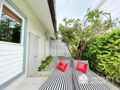 Charming garden area with stylish loungers and lush greenery, perfect for relaxation and outdoor enjoyment.