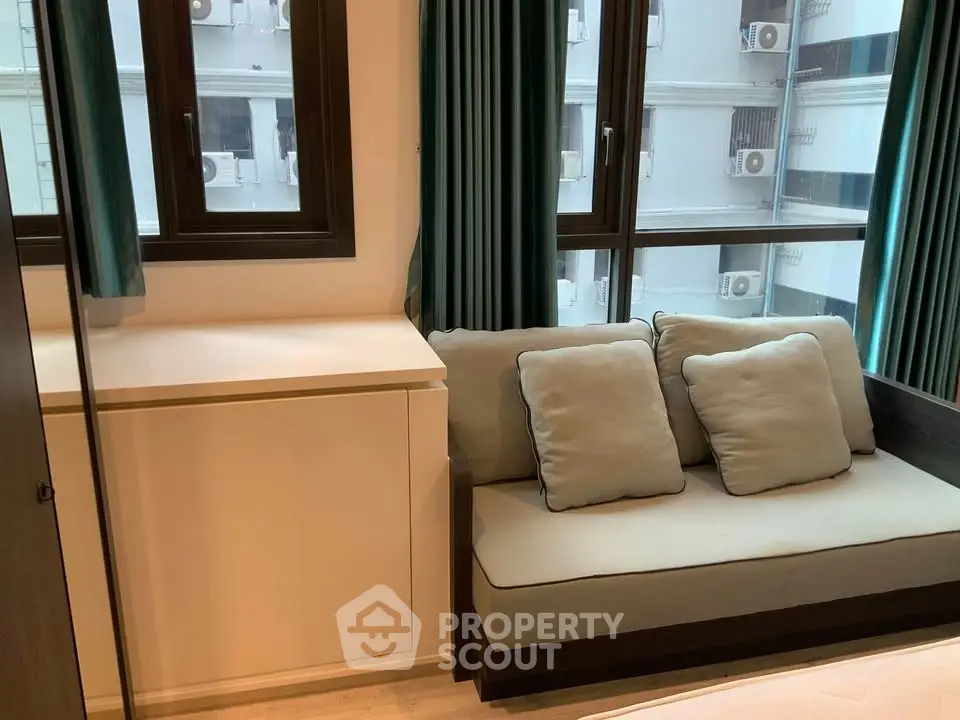 Cozy living room with modern sofa and large windows offering natural light.