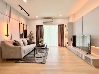 Modern living room with stylish decor and large TV, perfect for relaxation.