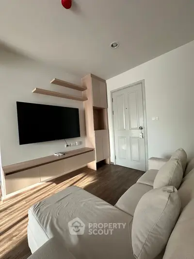 Modern living room with sleek TV setup and cozy sofa, perfect for relaxation.