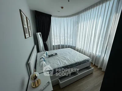 Modern bedroom with large windows and stylish decor in a high-rise apartment.