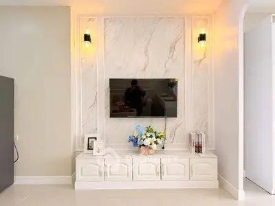 Elegant living room with marble accent wall and modern TV setup