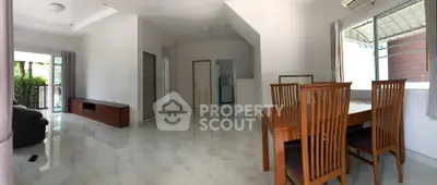 Spacious living room with modern dining area and large windows