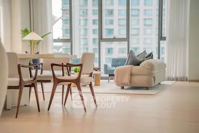 Spacious modern living room with elegant furniture and large windows offering city views.