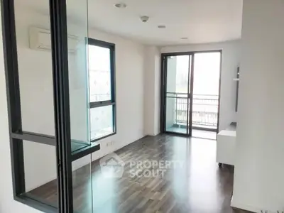 Spacious modern living room with large windows and balcony access