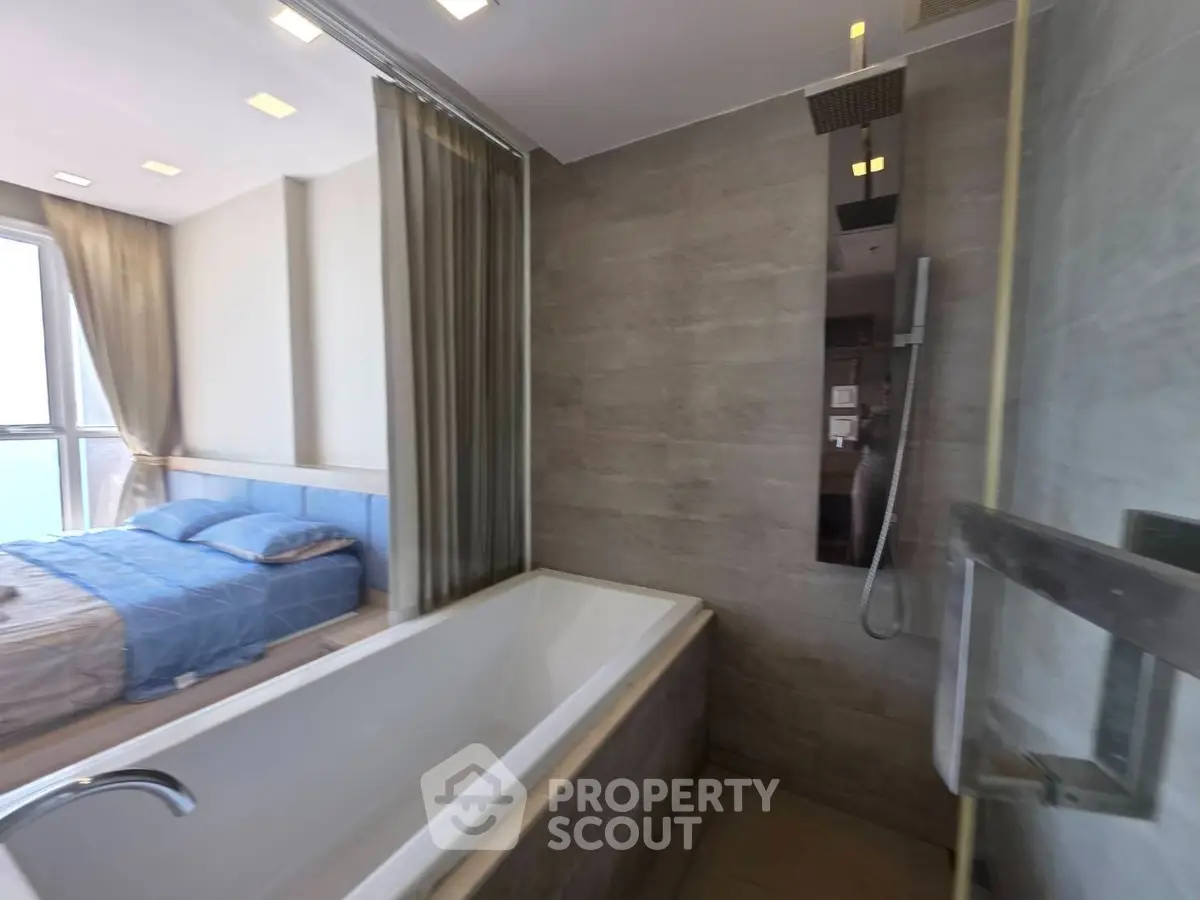 Modern bathroom with bathtub and adjacent bedroom in luxury apartment