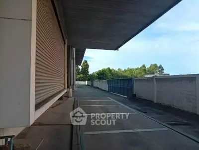 Spacious industrial warehouse exterior with loading dock and ample parking space.
