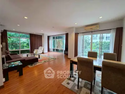 Spacious living room with elegant dining area and lush garden view, perfect for modern living.