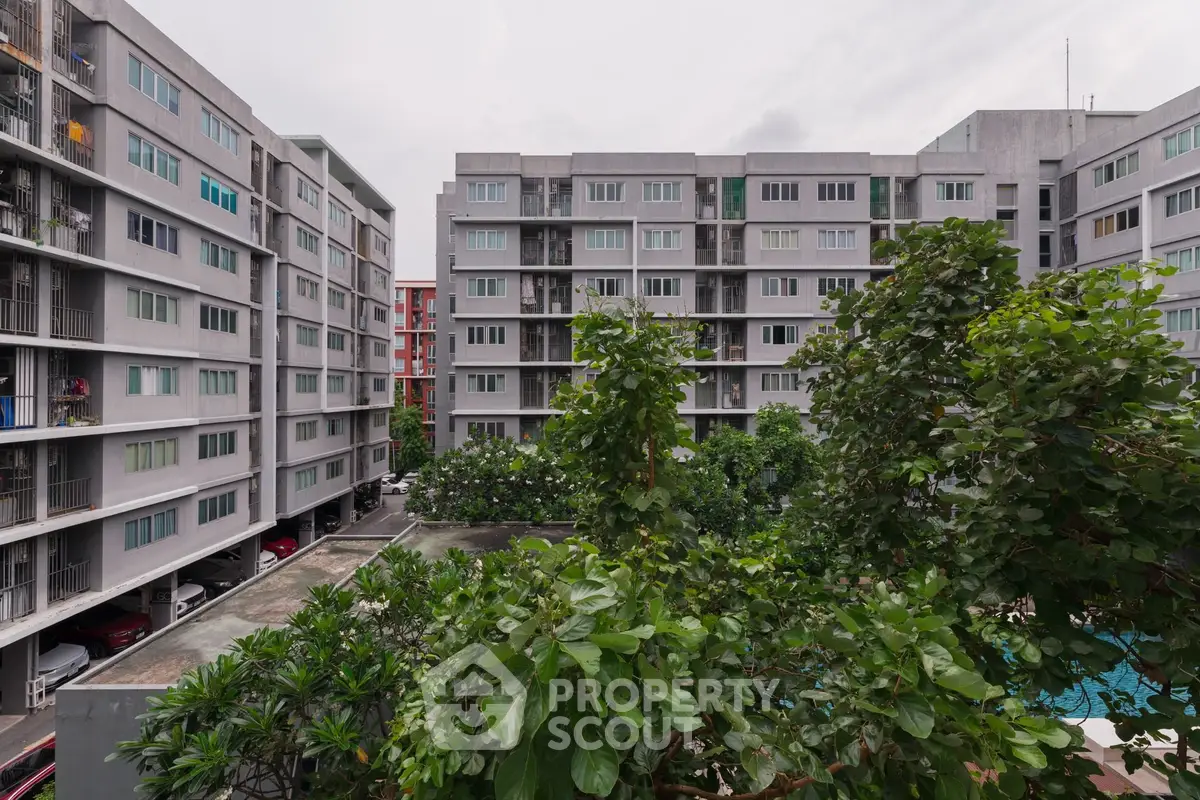 Modern apartment complex with lush greenery and urban architecture.