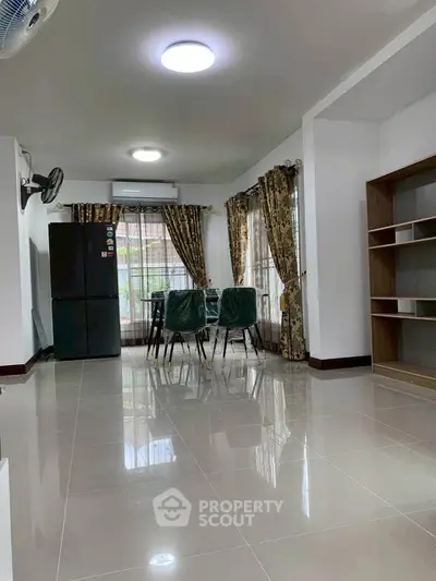Spacious open-plan living area with dining set and modern kitchen appliances.
