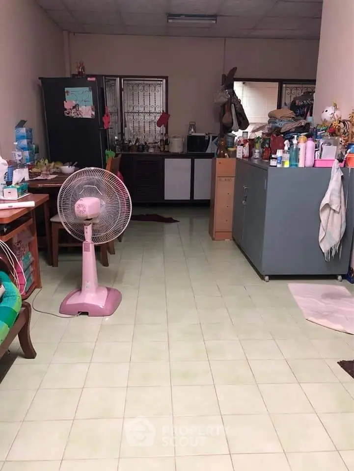 Cozy kitchen area with tiled floor and essential appliances, perfect for compact living spaces.