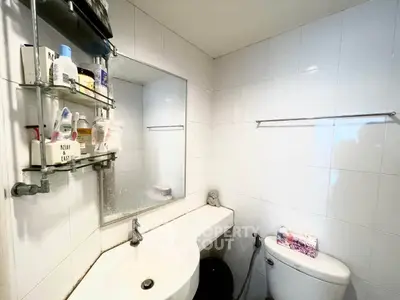 Compact bathroom with modern fixtures and wall-mounted storage shelves.