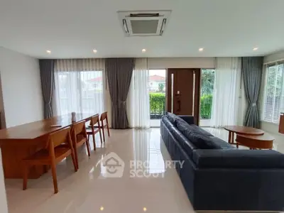 Spacious modern living room with elegant furniture and large windows offering natural light.