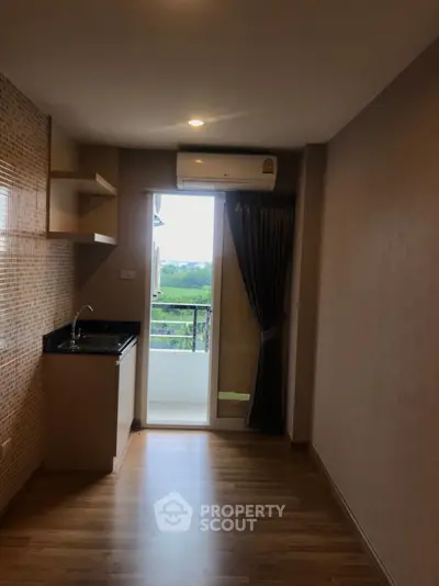 Compact kitchen with balcony view in modern apartment