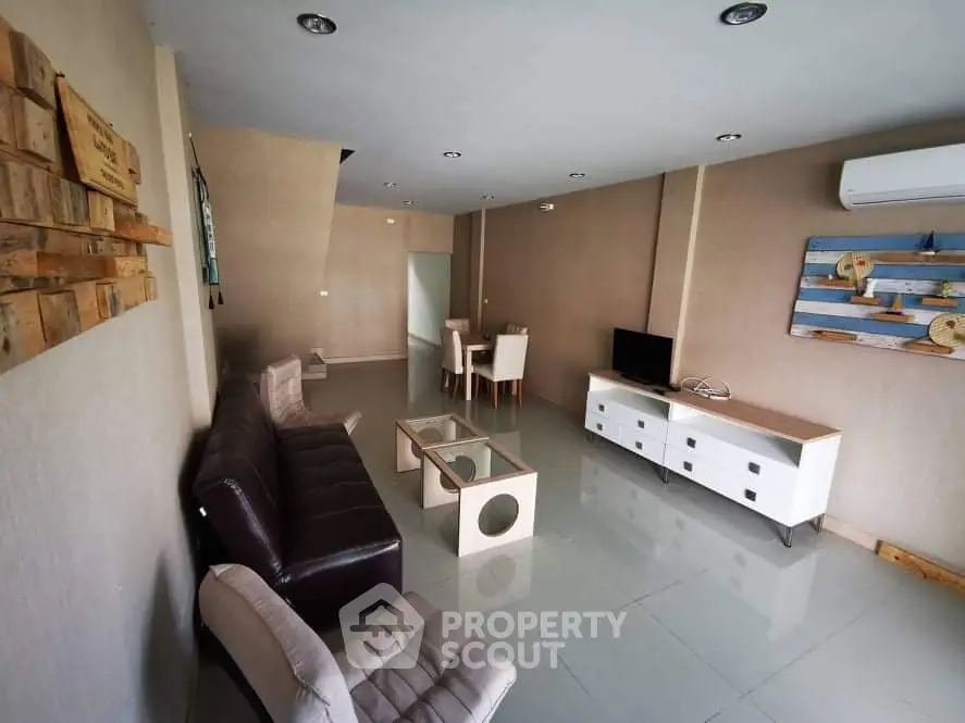 Spacious living room with modern furniture and air conditioning.