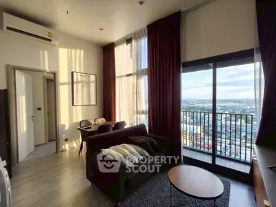 Modern living room with large windows and stunning city view, featuring cozy seating and elegant decor.