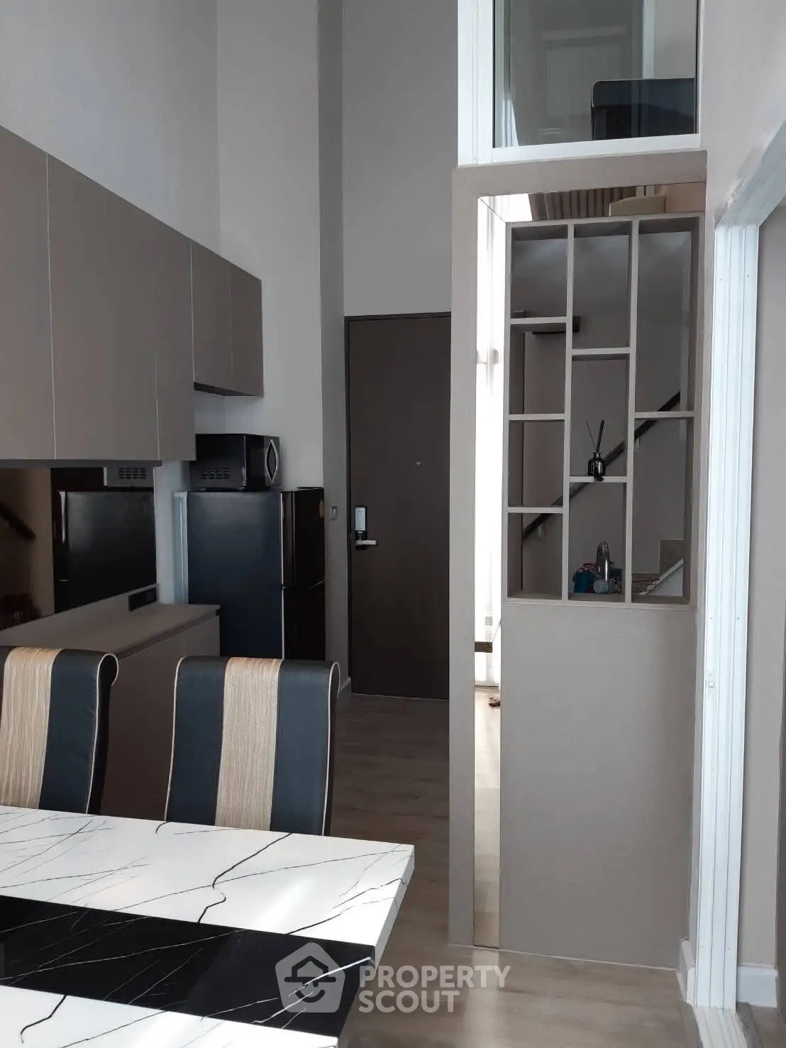 Modern kitchen with sleek cabinetry and dining area in stylish apartment