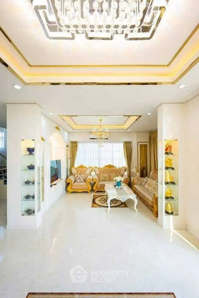 Luxurious living room with elegant chandelier and plush seating in a spacious, well-lit area.