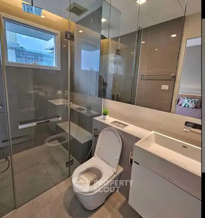 Modern bathroom with glass shower and sleek fixtures in a contemporary apartment.