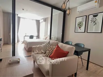 Modern open-plan living room with stylish decor and natural light in a cozy apartment.