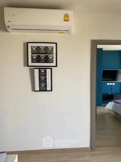 Modern bedroom with air conditioning and framed art on the wall, showcasing sleek design.