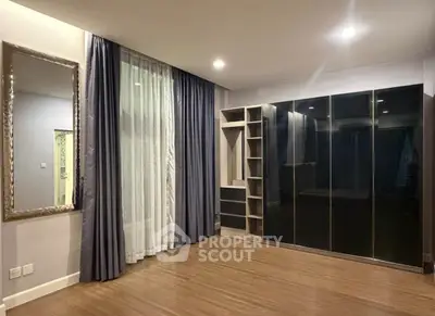 Spacious bedroom with elegant wardrobe and floor-to-ceiling curtains