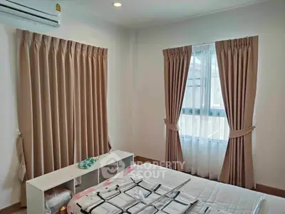 Cozy bedroom with air conditioning and elegant curtains, perfect for relaxation.
