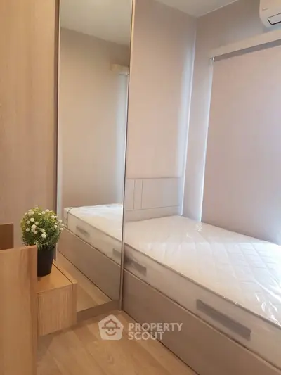 Cozy minimalist bedroom with mirrored wardrobe and natural light