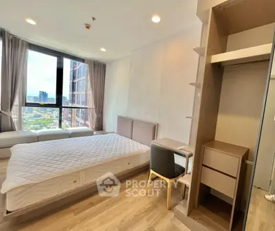 Spacious bedroom with large window offering stunning city views, modern furnishings, and ample natural light.