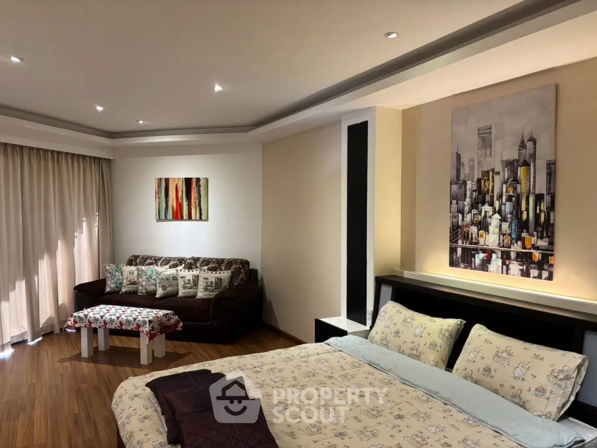 Spacious bedroom with cozy seating area and modern decor