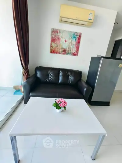 Modern living room with sleek black sofa, air conditioning, and stylish decor.