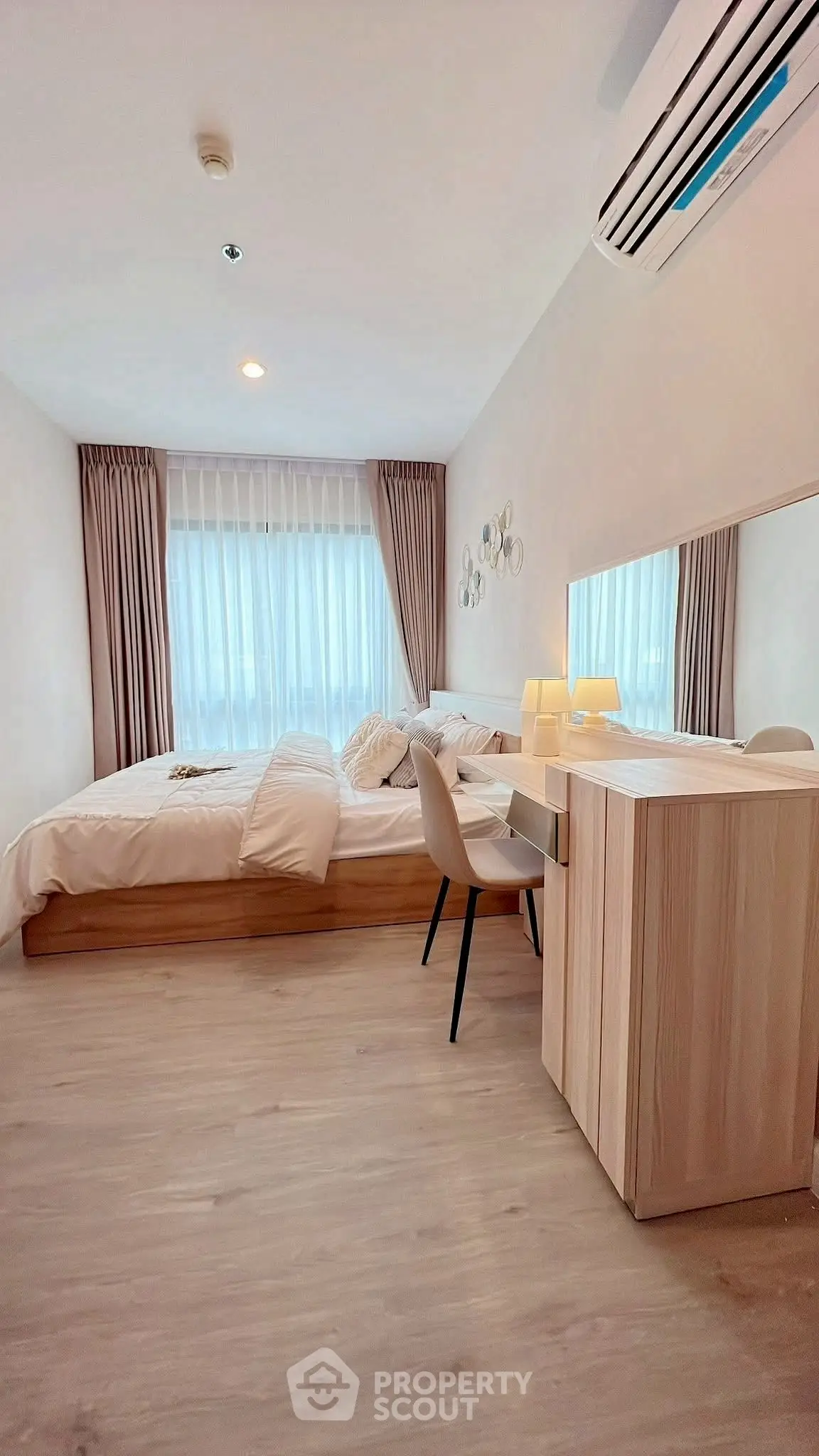 Cozy bedroom with modern decor and natural light, featuring a stylish desk and comfortable bed.