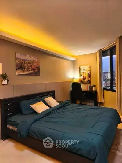 Modern bedroom with ambient lighting and stylish decor, featuring a cozy bed and workspace by the window.