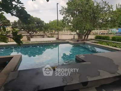 Luxurious outdoor pool surrounded by lush greenery, perfect for relaxation and leisure.