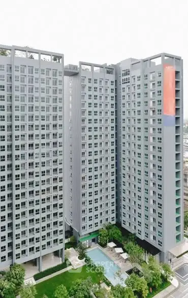 Modern high-rise residential building with pool and lush greenery