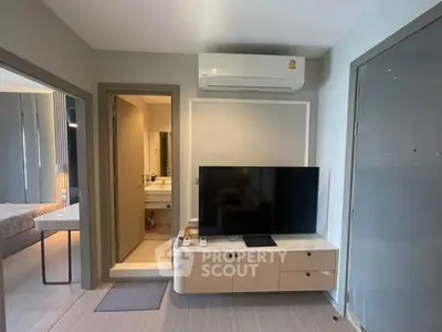 Modern living room with TV and air conditioning, adjacent to bedroom and bathroom.
