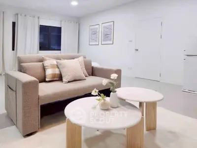 Modern living room with cozy sofa and stylish decor in a bright, minimalist setting.